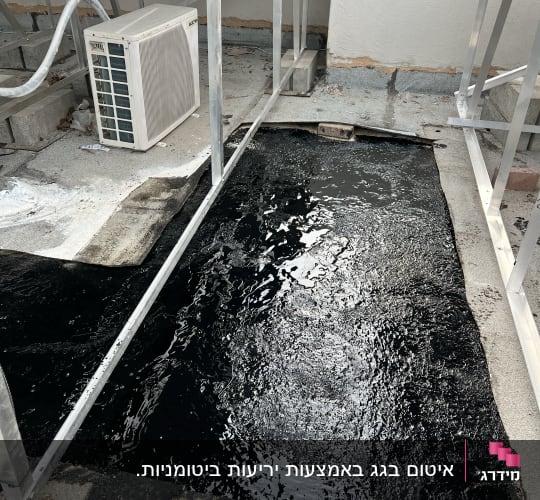 אזור אטום בזפת שחורה על גג בטון